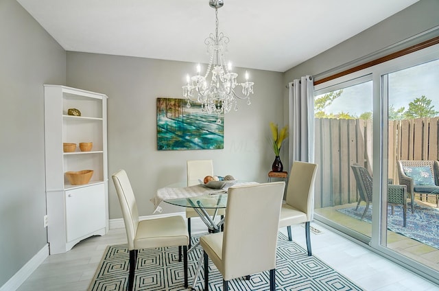 dining area with light hardwood / wood-style flooring and a notable chandelier