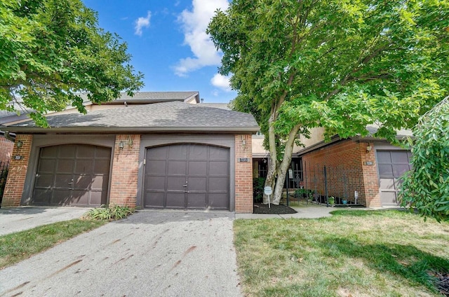 ranch-style home featuring a garage and a front lawn