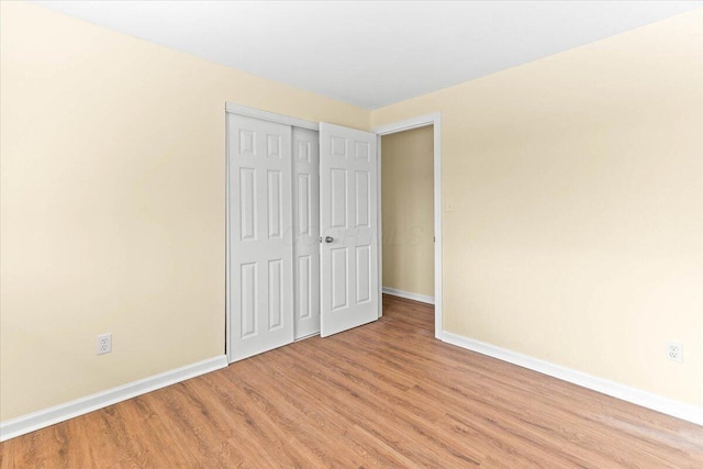 unfurnished bedroom with a closet and light hardwood / wood-style floors