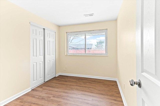 unfurnished bedroom featuring wood-type flooring and a closet