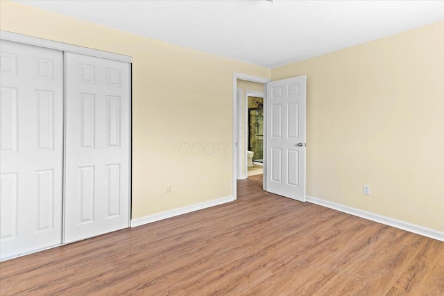 unfurnished bedroom featuring a closet and hardwood / wood-style floors