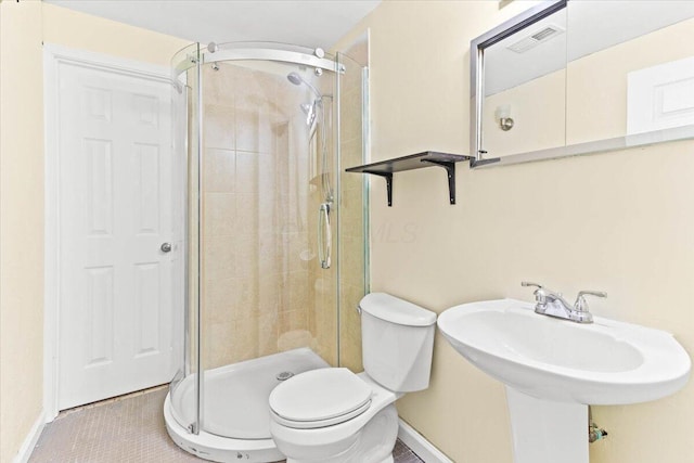 bathroom with tile patterned floors, sink, an enclosed shower, and toilet