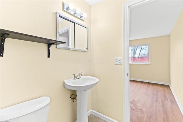 bathroom with hardwood / wood-style flooring and toilet