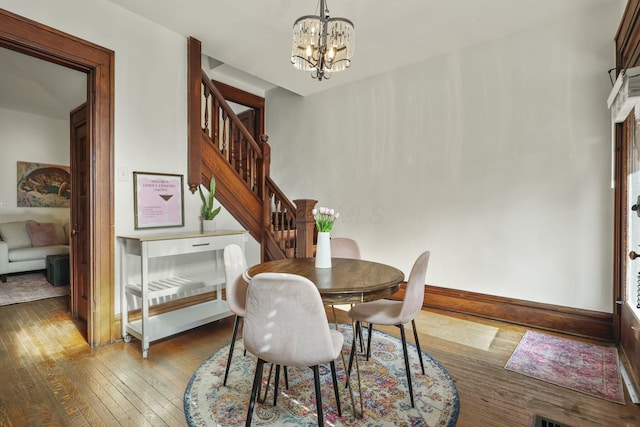 dining space with light wood-type flooring and a notable chandelier