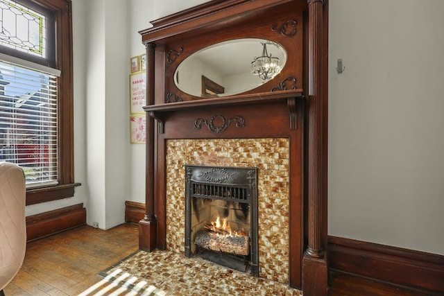 room details featuring wood-type flooring and a tiled fireplace