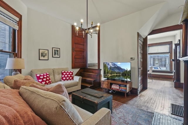 living room with dark wood-type flooring and a notable chandelier