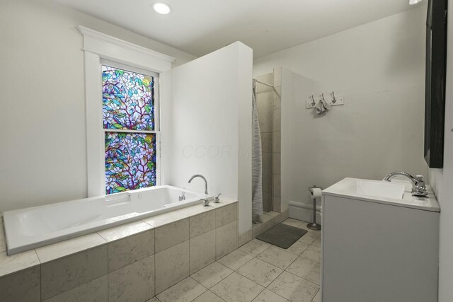 bathroom featuring plus walk in shower, vanity, and tile patterned flooring