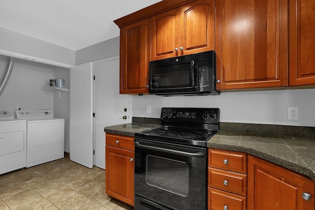 kitchen featuring separate washer and dryer, light tile patterned flooring, and black appliances