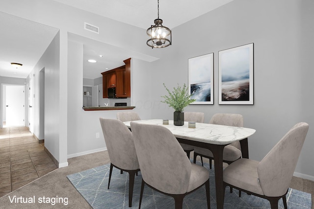 carpeted dining area with a chandelier