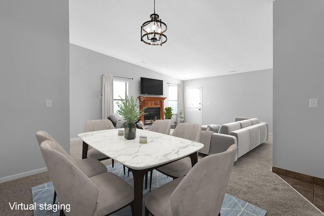 carpeted dining room featuring vaulted ceiling and an inviting chandelier