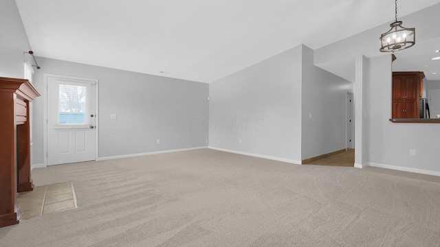 unfurnished living room featuring light carpet and a notable chandelier