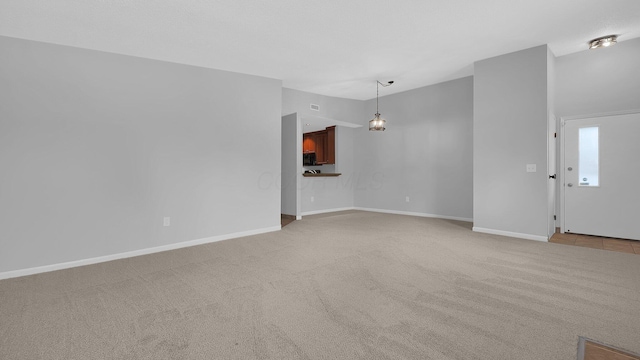 unfurnished living room featuring light carpet