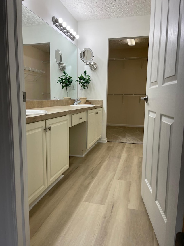 bathroom featuring vanity, a textured ceiling, and hardwood / wood-style flooring