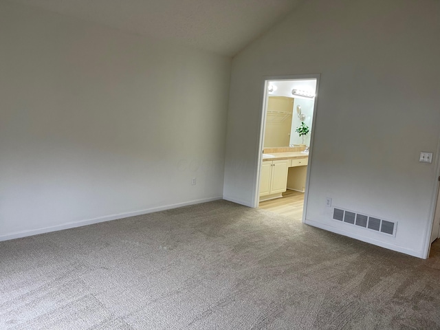 empty room featuring light colored carpet and high vaulted ceiling