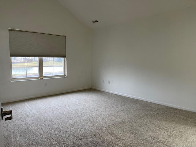 spare room featuring carpet flooring and high vaulted ceiling