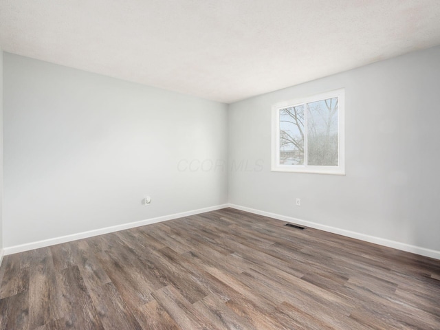 spare room featuring dark hardwood / wood-style floors