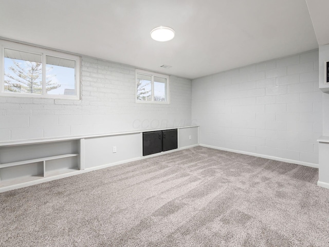 basement with carpet floors and brick wall