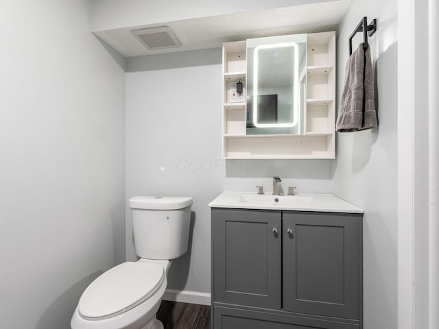 bathroom with vanity, toilet, and wood-type flooring