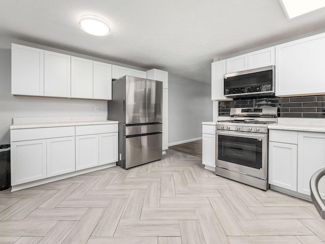 kitchen with decorative backsplash, white cabinetry, stainless steel appliances, and a textured ceiling