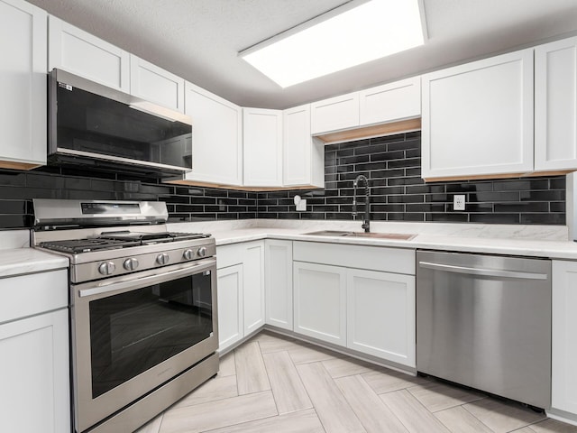 kitchen featuring white cabinets, appliances with stainless steel finishes, and sink