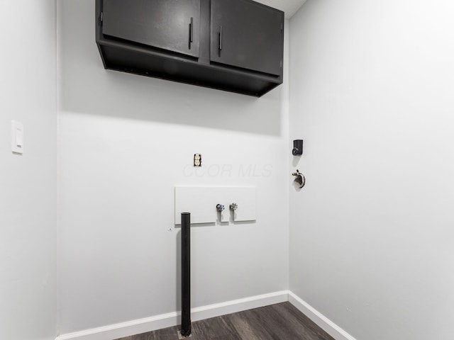 laundry area featuring washer hookup, cabinets, and dark wood-type flooring