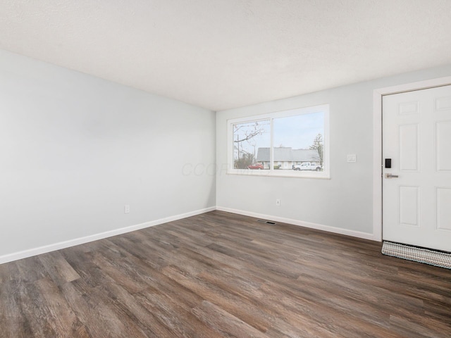 empty room with dark hardwood / wood-style floors