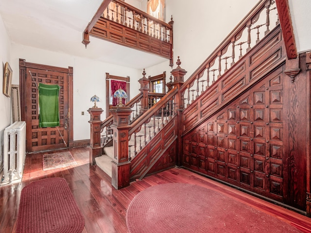 stairs with hardwood / wood-style flooring and radiator