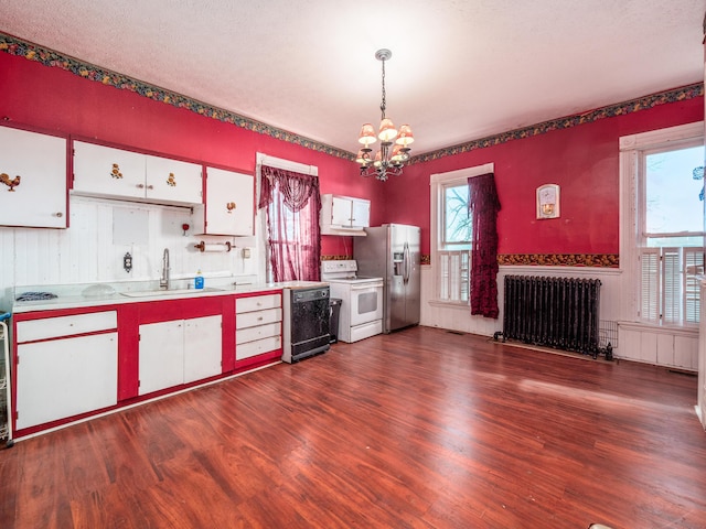 kitchen featuring radiator, white cabinets, sink, hanging light fixtures, and white range with electric stovetop