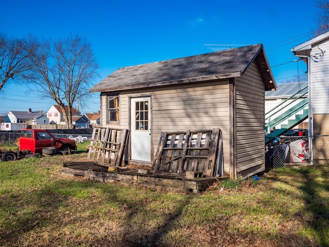 rear view of house with a yard and an outdoor structure