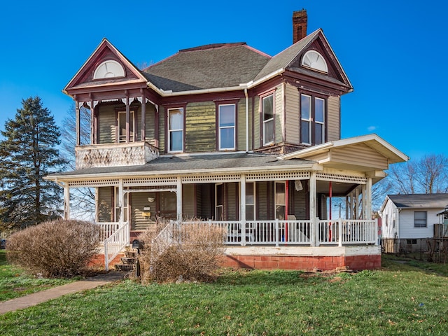 victorian-style house featuring a front lawn and a porch