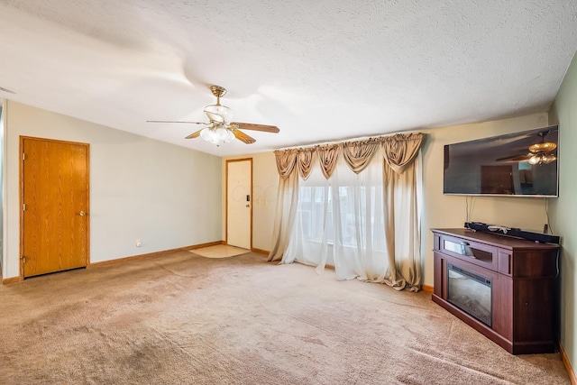 unfurnished living room featuring lofted ceiling, ceiling fan, light colored carpet, and a textured ceiling