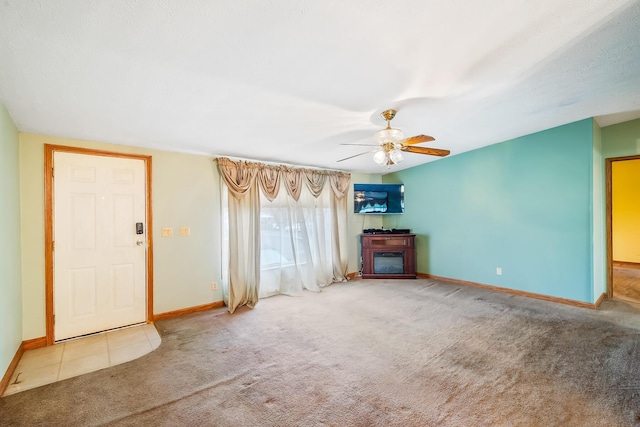 unfurnished living room featuring ceiling fan and light colored carpet