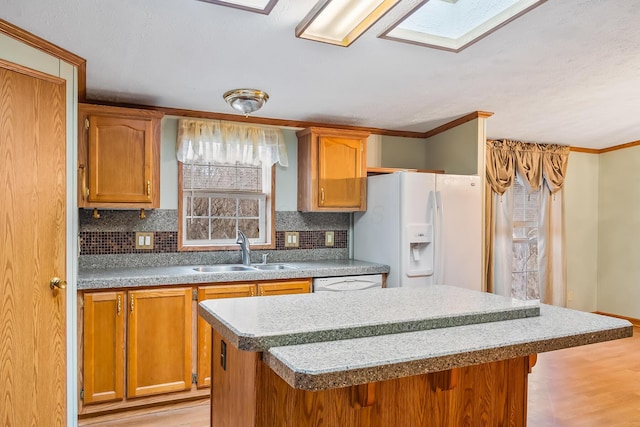 kitchen with sink, white appliances, decorative backsplash, a breakfast bar, and light wood-type flooring