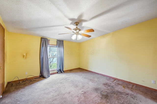 carpeted spare room with ceiling fan and a textured ceiling