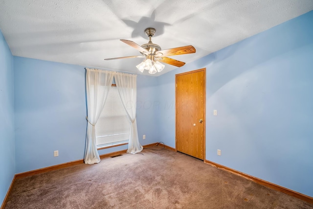 carpeted spare room featuring ceiling fan and a textured ceiling