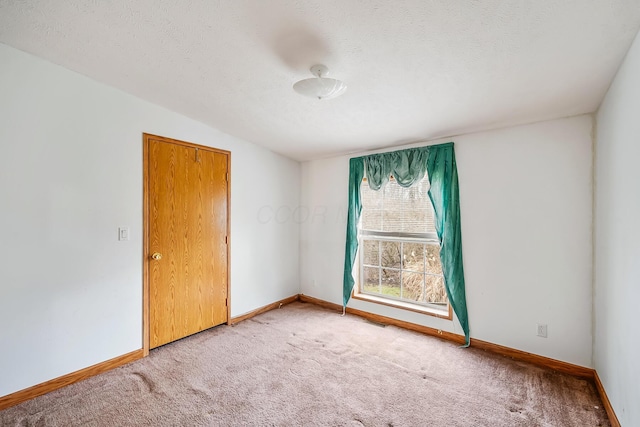 spare room with a textured ceiling and carpet floors