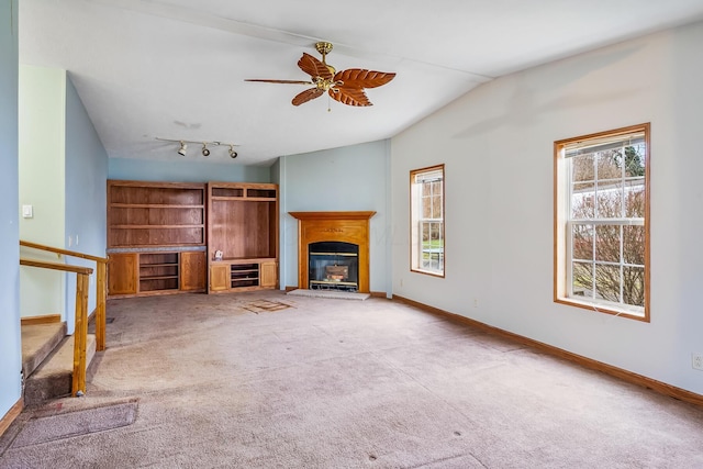 unfurnished living room with ceiling fan, lofted ceiling, light carpet, and track lighting