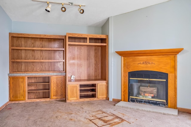 unfurnished living room featuring carpet floors and rail lighting