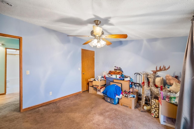 interior space with ceiling fan, carpet floors, and a textured ceiling