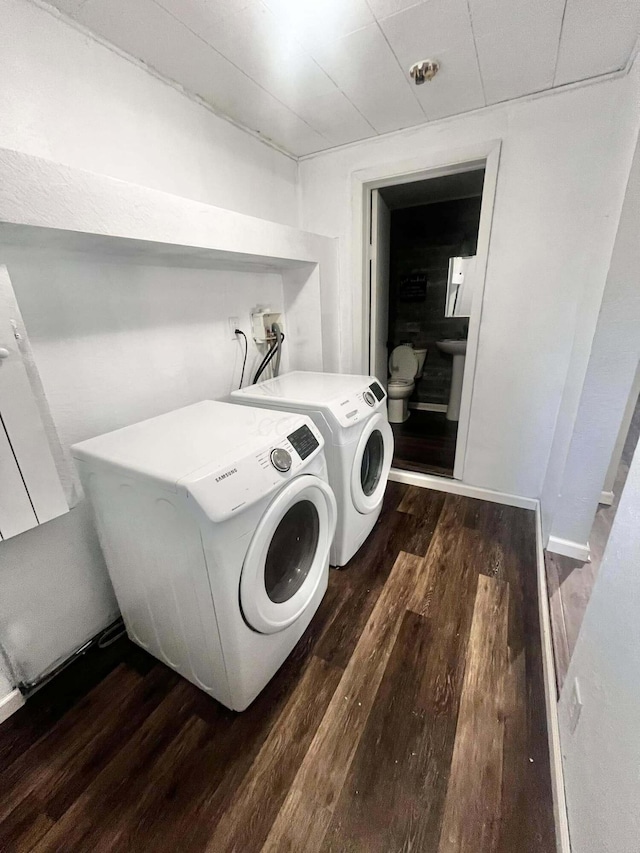 laundry room with dark hardwood / wood-style floors and washer and clothes dryer