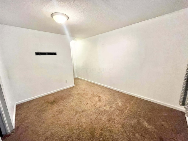 empty room featuring carpet floors and a textured ceiling