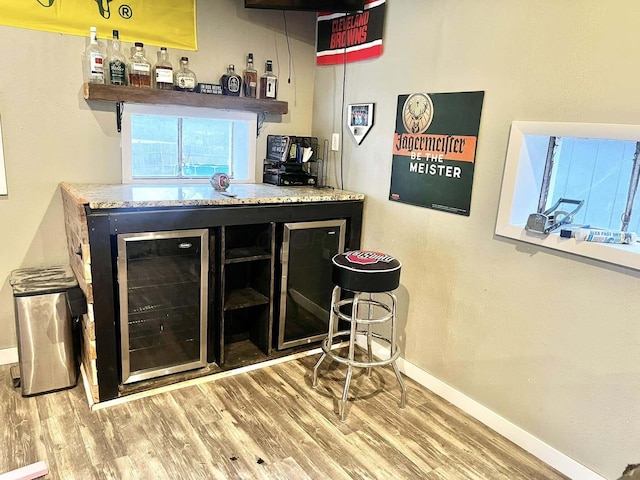 bar featuring hardwood / wood-style flooring and wine cooler