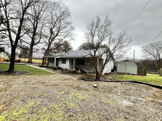 back of property with a lawn and a shed