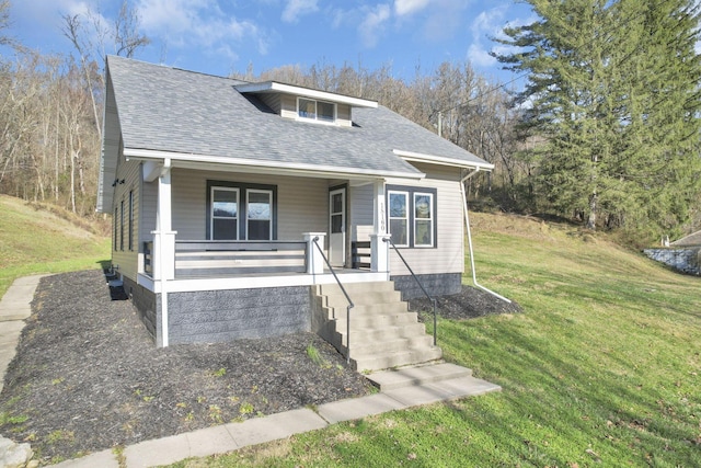 bungalow-style house featuring covered porch and a front lawn