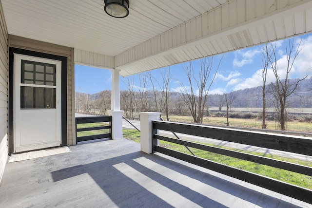 deck featuring a mountain view and covered porch