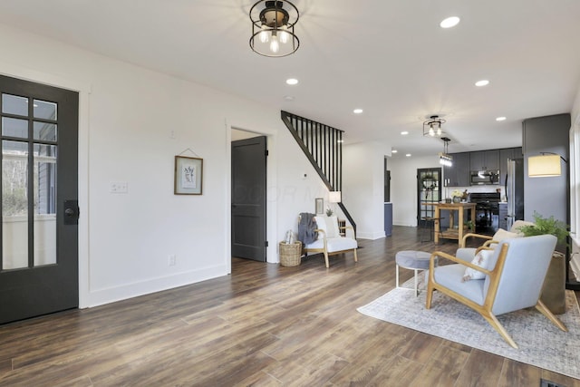 living room with dark wood-type flooring and an inviting chandelier