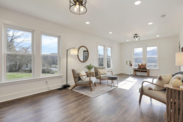 living room featuring a wealth of natural light and dark wood-type flooring