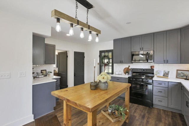 kitchen with gray cabinetry, black gas stove, and tasteful backsplash