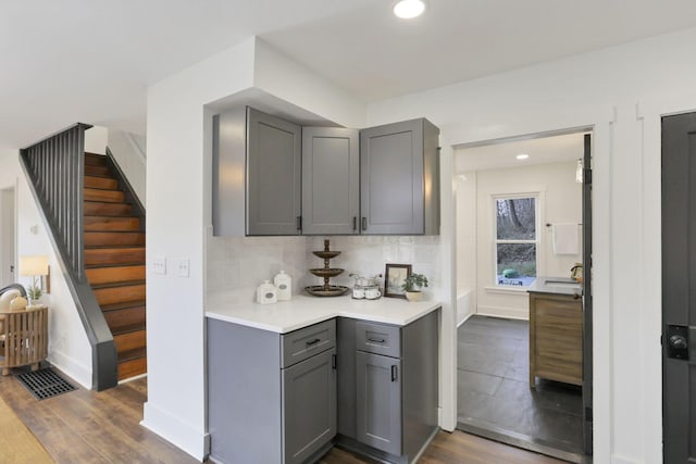 kitchen featuring backsplash, gray cabinets, and dark hardwood / wood-style floors