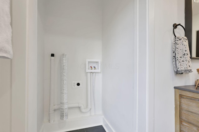 clothes washing area featuring hookup for a washing machine, dark tile patterned flooring, and hookup for an electric dryer